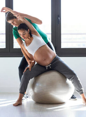 istockphoto-1176994575-612x612 Pregnant woman receiving prenatal physiotherapy with an exercise ball."