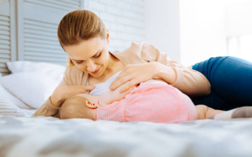 Mother breastfeeding her baby in a serene and comfortable home setting.
