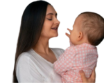 A mother lovingly holds her baby in a moment of joyful connection.
